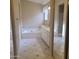 Bright bathroom with a large soaking tub, dual sinks, and decorative tile flooring at 10622 W Mohawk Ln, Peoria, AZ 85382