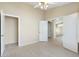 Spacious bedroom featuring light floors, a ceiling fan, and a view of another room through a doorway at 10622 W Mohawk Ln, Peoria, AZ 85382