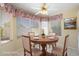 Virtually staged breakfast nook with round table, floral valances, and tile flooring at 10622 W Mohawk Ln, Peoria, AZ 85382