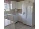 Bright kitchen features white appliances including a refrigerator and dishwasher, tile floors, and ample cabinet space at 10622 W Mohawk Ln, Peoria, AZ 85382