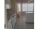 Clean kitchen area with white cabinetry, a breakfast bar, and tile flooring at 10622 W Mohawk Ln, Peoria, AZ 85382