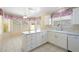 Sunlit kitchen with white cabinetry, marble counters, and breakfast nook at 10622 W Mohawk Ln, Peoria, AZ 85382