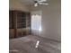 Spacious living area features plush carpeting, large window and a wooden built-in bookcase at 10622 W Mohawk Ln, Peoria, AZ 85382