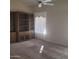 Spacious carpeted living room with built in wooden bookcase and storage. Natural light from large window at 10622 W Mohawk Ln, Peoria, AZ 85382