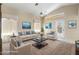 Virtually staged living room with vaulted ceiling, transom windows, and comfortable seating at 10622 W Mohawk Ln, Peoria, AZ 85382