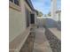 Side yard featuring a walkway, decorative rock landscaping, and a white fence at 10622 W Mohawk Ln, Peoria, AZ 85382