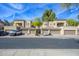 A tan two-story townhome featuring private garages, balconies, and tile roofing under a blue sky at 11000 N 77Th Pl # 2032, Scottsdale, AZ 85260