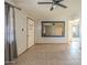 Living room featuring neutral tile flooring, ceiling fan, and entry door at 11305 W Alabama Ave, Youngtown, AZ 85363