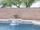 Inviting pool with waterfall feature, surrounded by lush greenery and a secure brick wall at 11335 E Cicero St, Mesa, AZ 85207