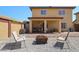 Relaxing backyard includes covered patio, decorative rock, seating, and fire pit at 12054 W Aster W Dr, El Mirage, AZ 85335