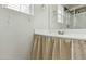 Bathroom with a curtained vanity, mirror, and a shower with glass doors at 12054 W Aster W Dr, El Mirage, AZ 85335