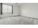Bright bedroom features neutral carpet, light gray walls, and a window with gray curtains at 12054 W Aster W Dr, El Mirage, AZ 85335