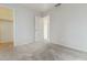 Bright bedroom featuring neutral carpet, closet, and open door to additional room at 12054 W Aster W Dr, El Mirage, AZ 85335