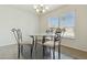 Cozy dining space with a glass table, stylish chairs, and a bright window at 12054 W Aster W Dr, El Mirage, AZ 85335