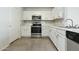 Bright kitchen features white cabinets, stainless steel appliances, and neutral tile flooring at 12054 W Aster W Dr, El Mirage, AZ 85335
