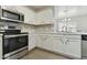 Well-lit kitchen showcasing stainless steel appliances, and white cabinetry at 12054 W Aster W Dr, El Mirage, AZ 85335