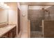 Bathroom featuring a sink vanity with granite countertops and a glass-enclosed shower with tile surround at 13913 W Whitewood Dr, Sun City West, AZ 85375
