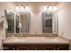 Bathroom featuring a double sink vanity with granite countertops and decorative mirrors at 13913 W Whitewood Dr, Sun City West, AZ 85375