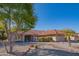 Inviting home featuring a red tile roof, complemented by desert landscaping and mature trees at 13913 W Whitewood Dr, Sun City West, AZ 85375