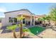Charming backyard showcasing desert landscaping, a covered patio, and a well-maintained yard at 15770 W Remington Dr, Surprise, AZ 85374