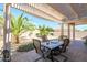 Inviting covered patio with dining table and chairs, set amongst a desert landscaped backyard at 15770 W Remington Dr, Surprise, AZ 85374