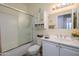 Bright bathroom featuring a shower-tub combo, white cabinets, and a large mirror at 15770 W Remington Dr, Surprise, AZ 85374