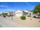 Attractive single-story home with desert landscaping, complemented by a spacious driveway and well-manicured lawn at 15770 W Remington Dr, Surprise, AZ 85374