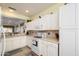 Bright kitchen featuring white appliances, white cabinets, tile countertops, and ample natural light at 15770 W Remington Dr, Surprise, AZ 85374