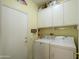 Efficient laundry room featuring a washer, dryer, and built-in shelving and cabinets at 15770 W Remington Dr, Surprise, AZ 85374