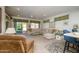 Open-concept living room with a large sectional, neutral carpeting, and access to the backyard at 15770 W Remington Dr, Surprise, AZ 85374