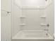 Bright white tub-shower combination features built-in shelving at 16020 W Hackamore Dr, Surprise, AZ 85387