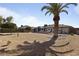Expansive backyard with gravel landscaping, mature trees, covered patio, and a barbecue grill at 17410 N Conquistador Dr, Sun City West, AZ 85375