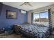 Bedroom featuring a blue accent wall, ceiling fan, and natural light from the window at 17410 N Conquistador Dr, Sun City West, AZ 85375