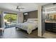 Bright bedroom featuring a ceiling fan, access to the backyard, and an attached ensuite bathroom at 17410 N Conquistador Dr, Sun City West, AZ 85375