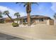 Charming single-story brick home featuring mature palm trees and low-maintenance desert landscaping at 17410 N Conquistador Dr, Sun City West, AZ 85375