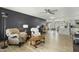 Open-concept living room featuring wood floors, a dark accent wall, and neutral-toned furniture at 17410 N Conquistador Dr, Sun City West, AZ 85375