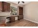 Office with hardwood floors, a built-in desk, cabinets, and a window with blinds at 17815 W Calistoga Dr, Surprise, AZ 85387
