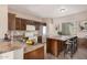 Traditional eat-in kitchen with stainless steel appliances, wooden cabinets, and a central island with bar stool seating at 17815 W Calistoga Dr, Surprise, AZ 85387
