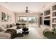 Bright living room featuring a large sectional sofa, neutral walls, ceiling fan, and sliding glass doors to the backyard at 17815 W Calistoga Dr, Surprise, AZ 85387