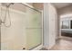 Modern shower with glass door, white tile, and a showerhead, plus built in storage at 17815 W Calistoga Dr, Surprise, AZ 85387