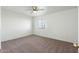 An empty bedroom featuring carpet floors, a window, and a ceiling fan at 18239 N 40Th St # 107, Phoenix, AZ 85032