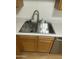 Close-up of the kitchen sink with stainless steel fixtures and a modern faucet, complemented by wooden cabinetry at 18239 N 40Th St # 107, Phoenix, AZ 85032