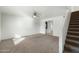 Cozy living room features neutral carpet, a ceiling fan, and a staircase to the upper level at 18239 N 40Th St # 107, Phoenix, AZ 85032
