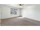 Sunny living room with neutral carpet, ceiling fan, and large window for natural light at 18239 N 40Th St # 107, Phoenix, AZ 85032