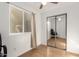 Bedroom featuring a mirrored closet, wood-look floor, and bright window at 19412 W Clarendon Ave, Litchfield Park, AZ 85340