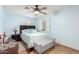 Calming bedroom featuring a ceiling fan, plantation shutters, light blue walls, and an upholstered bench at 19412 W Clarendon Ave, Litchfield Park, AZ 85340