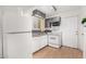 Functional kitchen with white appliances, gray countertops, white cabinets, and laminate flooring at 19412 W Clarendon Ave, Litchfield Park, AZ 85340