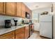Galley kitchen with stainless steel appliances, wood cabinetry and granite countertops at 19412 W Clarendon Ave, Litchfield Park, AZ 85340