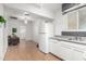 Bright kitchen features white appliances, gray countertops, white cabinets, and laminate flooring at 19412 W Clarendon Ave, Litchfield Park, AZ 85340