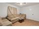 Cozy living room featuring a comfortable sectional sofa, ceiling fan, and light-colored laminate flooring at 19412 W Clarendon Ave, Litchfield Park, AZ 85340